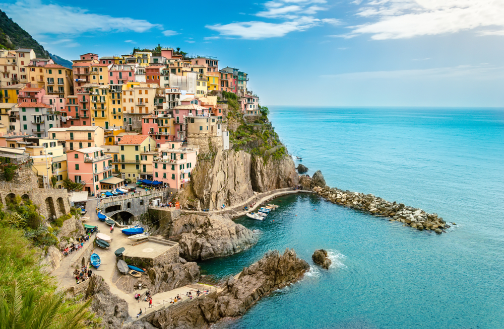 Ez a kép Manarolát, Olaszország Cinque Terre régiójának egyik faluját ábrázolja. A képen a falu sziklás partja és a Ligur-tenger látható.  - Z(s)eppelin utazás